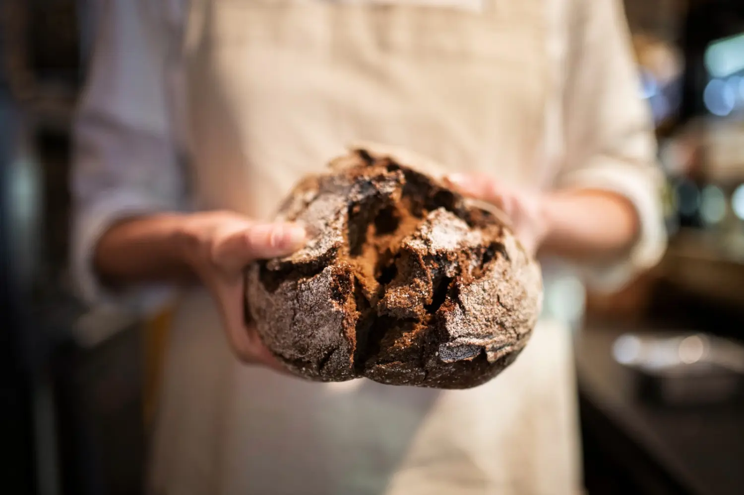 Nahaufnahme eines Bäckers mit Brot von Cavus Bäckerei GmbH